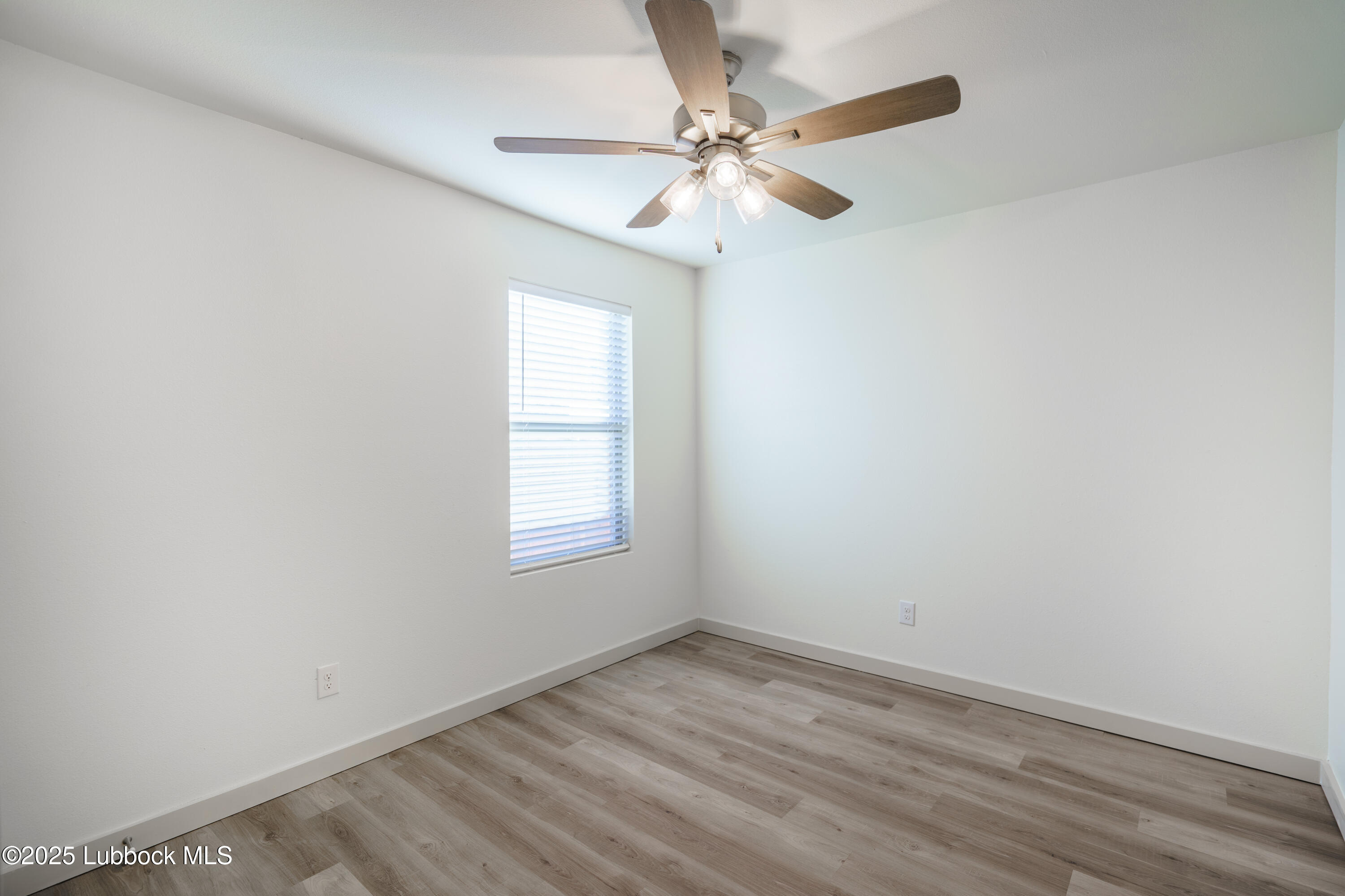 8010 Elm Avenue Lubbock, TX 79404 - Photo 9 of 15 an empty room with a window and a fan