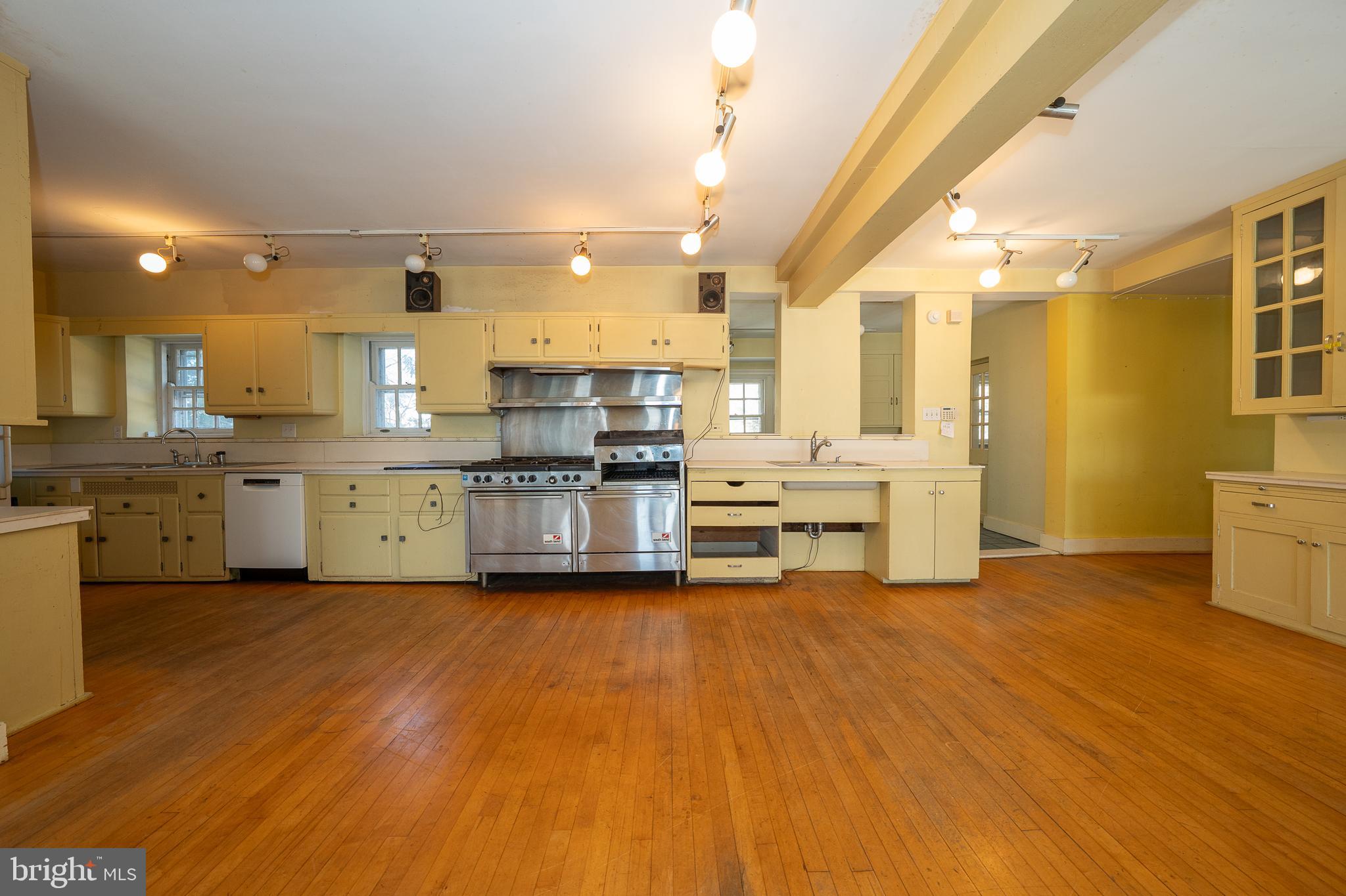 451 Merion Road Merion Station, PA 19066 - Photo 11 of 42 a view of kitchen with stainless steel appliances granite countertop a stove top oven a sink dishwasher and white cabinets with wooden floor