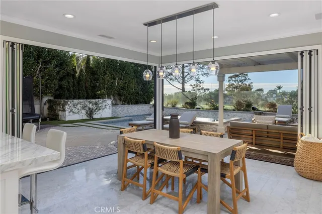 a dining room with wooden floor a chandelier a glass table and chairs