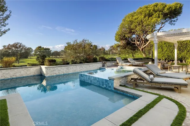 a view of a patio with couches table and chairs under an umbrella