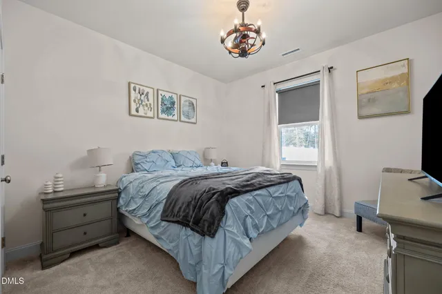 a bedroom with a bed and a tv on the dresser