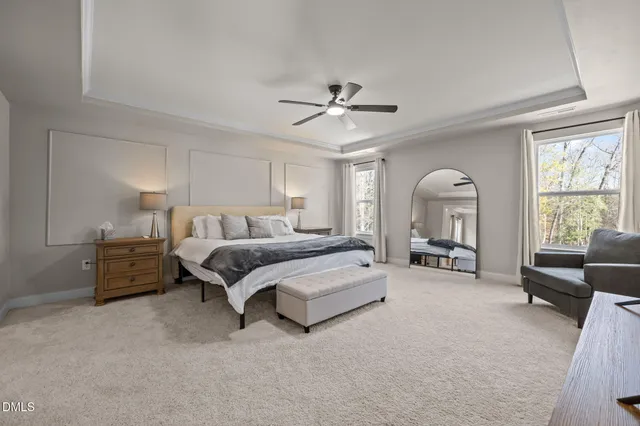 a spacious bedroom with a bed a couch and a large window