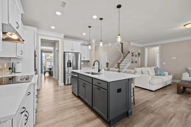 a kitchen with kitchen island a sink stove and wooden floor