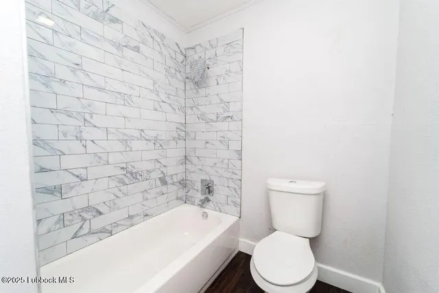 a white toilet sitting next to a shower
