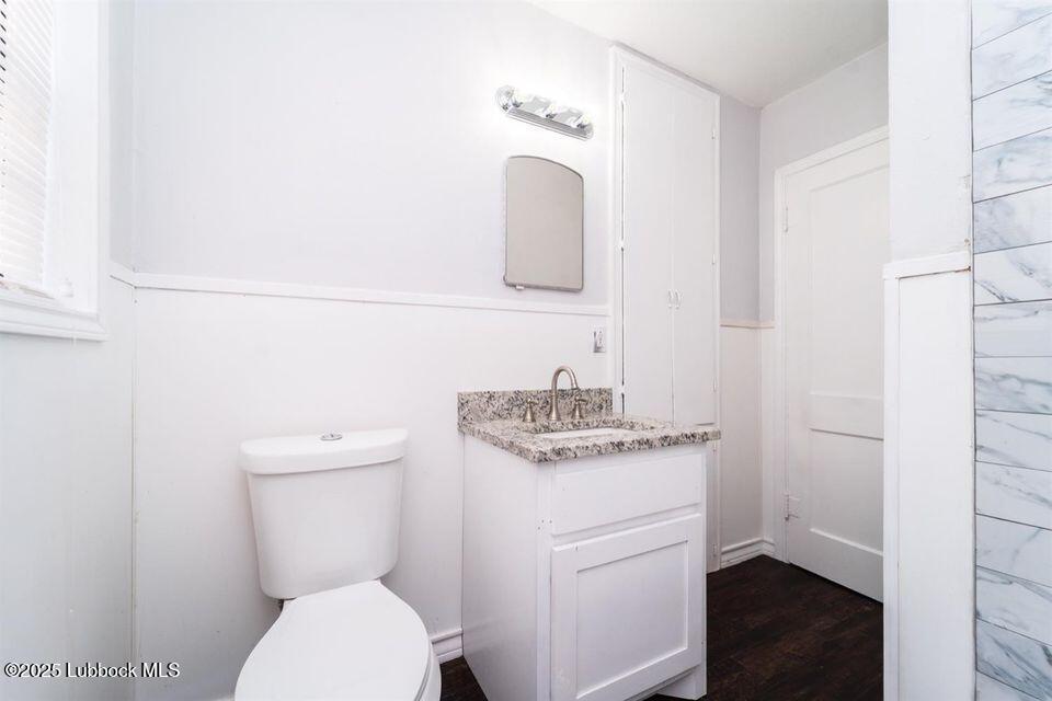 2503 30th Street Lubbock, TX 79410 - Photo 16 of 21 a bathroom with a granite countertop toilet sink and mirror