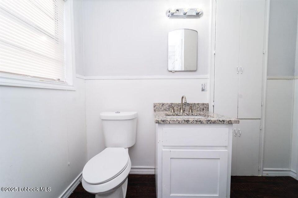 2503 30th Street Lubbock, TX 79410 - Photo 17 of 21 a bathroom with a toilet sink vanity and mirror