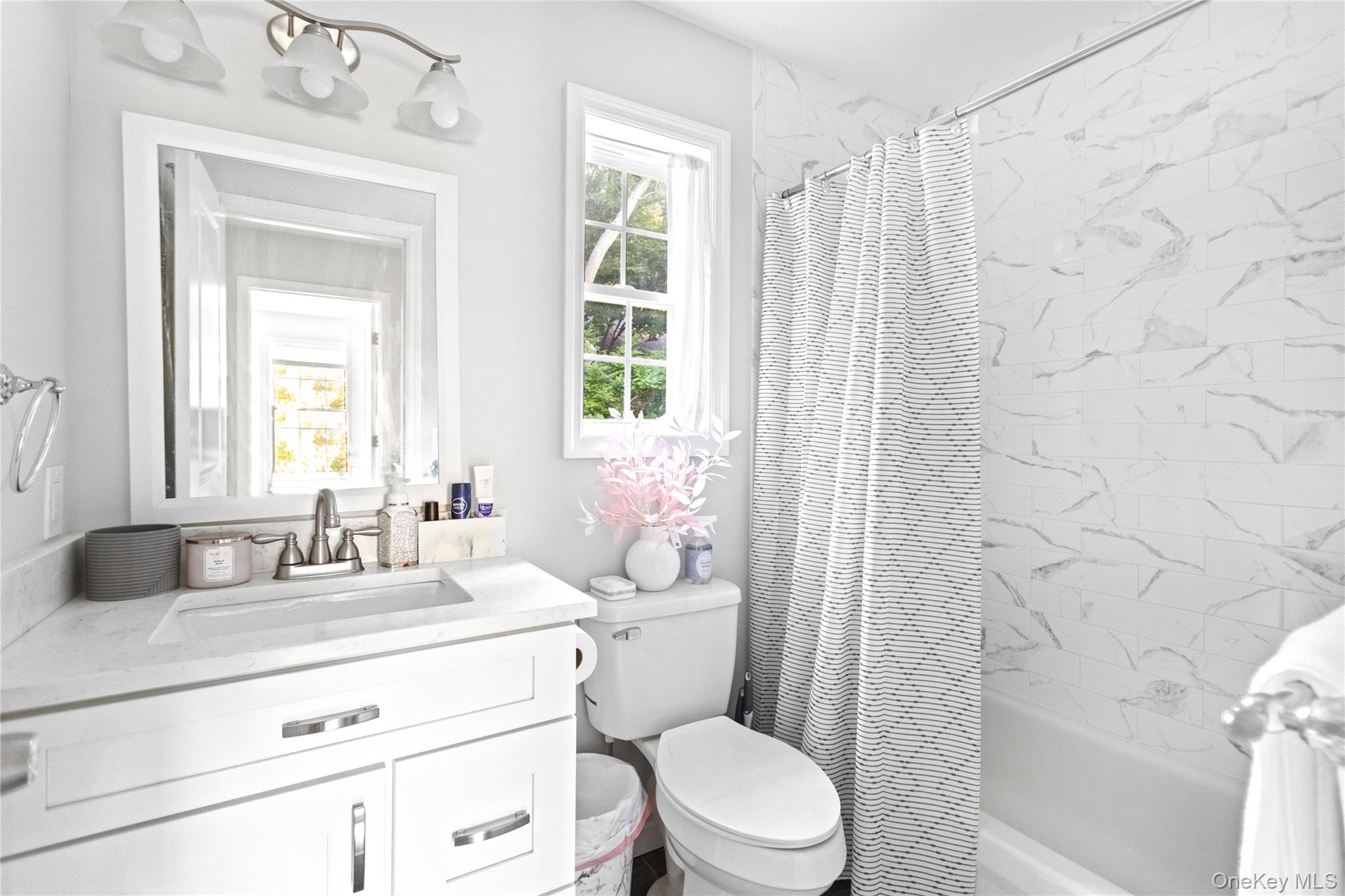 24 Belmont Road Sound Beach, NY 11789 - Photo 18 of 23 a bathroom with a granite countertop toilet a sink a mirror a window and vanity
