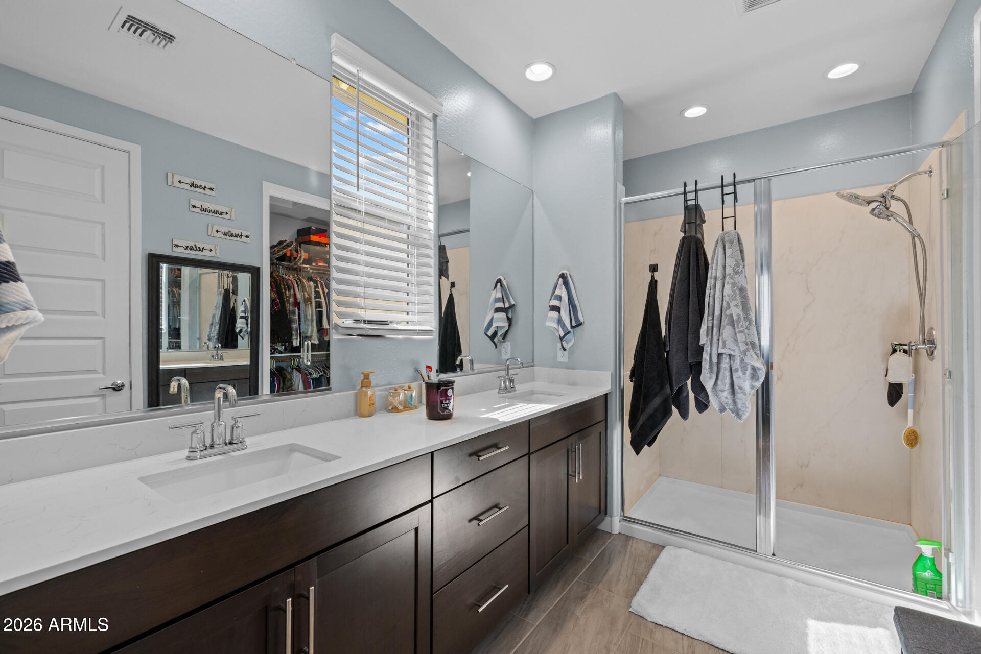 4143 East Appaloosa Road Gilbert, AZ 85296 - Photo 16 of 36 a bathroom with a double vanity sink a toilet a mirror and shower