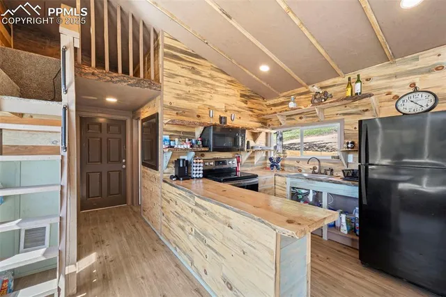 a kitchen with stainless steel appliances kitchen island granite countertop a refrigerator and a stove