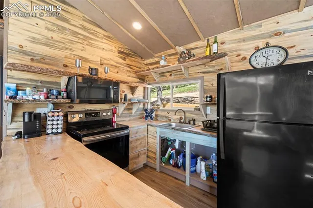a kitchen with a refrigerator and a stove top oven