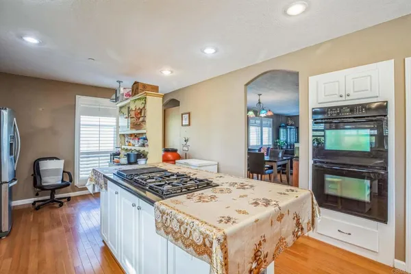 a large kitchen with a stove and a wooden floor