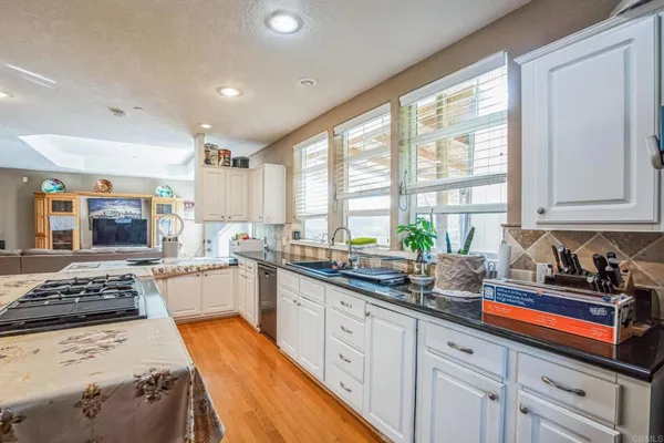 a kitchen with stainless steel appliances a sink a stove a window and cabinets