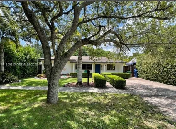 a front view of a house with yard tree and wooden fence