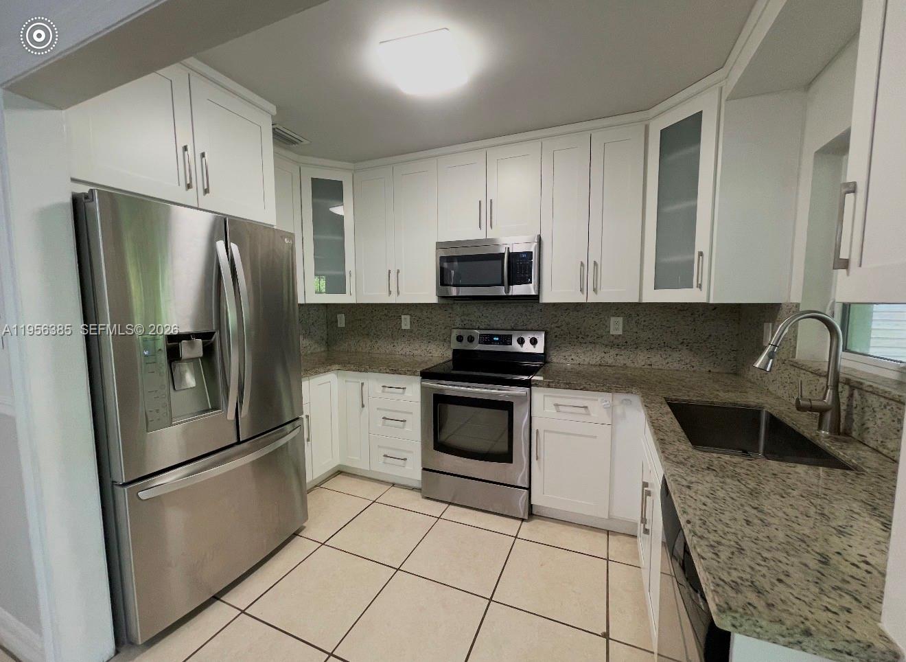 3614 Southwest 58th Avenue Miami, FL 33155 - Photo 14 of 27 a kitchen with stainless steel appliances granite countertop a refrigerator sink and stove