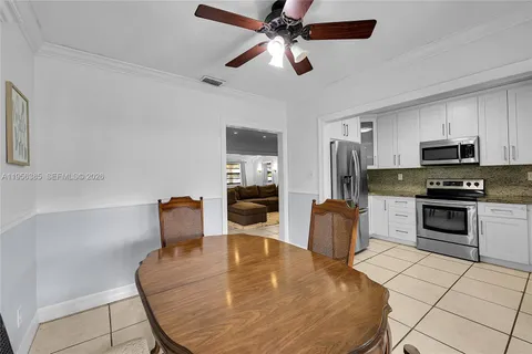 a kitchen with stainless steel appliances kitchen island granite countertop a refrigerator a stove top oven a sink with island and chairs