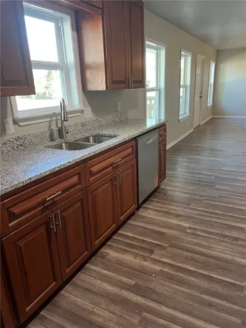 a kitchen with stainless steel appliances wooden cabinets a sink and a window
