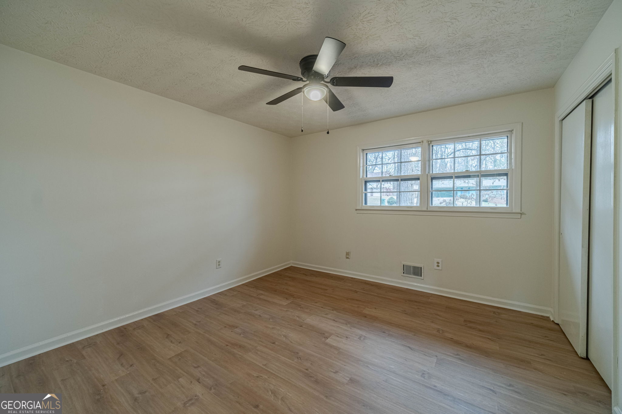 1678 Pounds Road Southwest Stone Mountain, GA 30087 - Photo 17 of 30 an empty room with wooden floor and windows