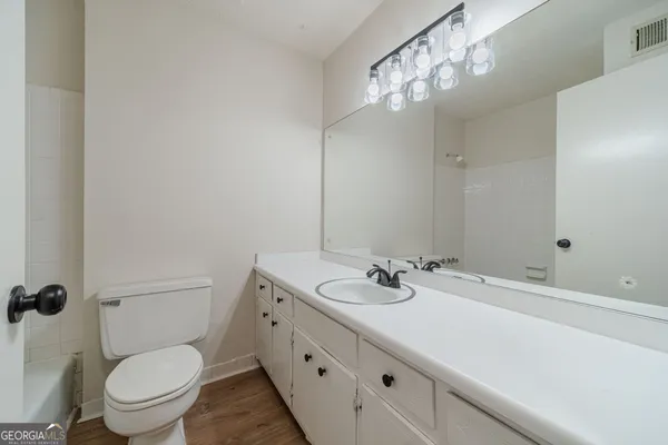 a bathroom with a sink a toilet and a mirror