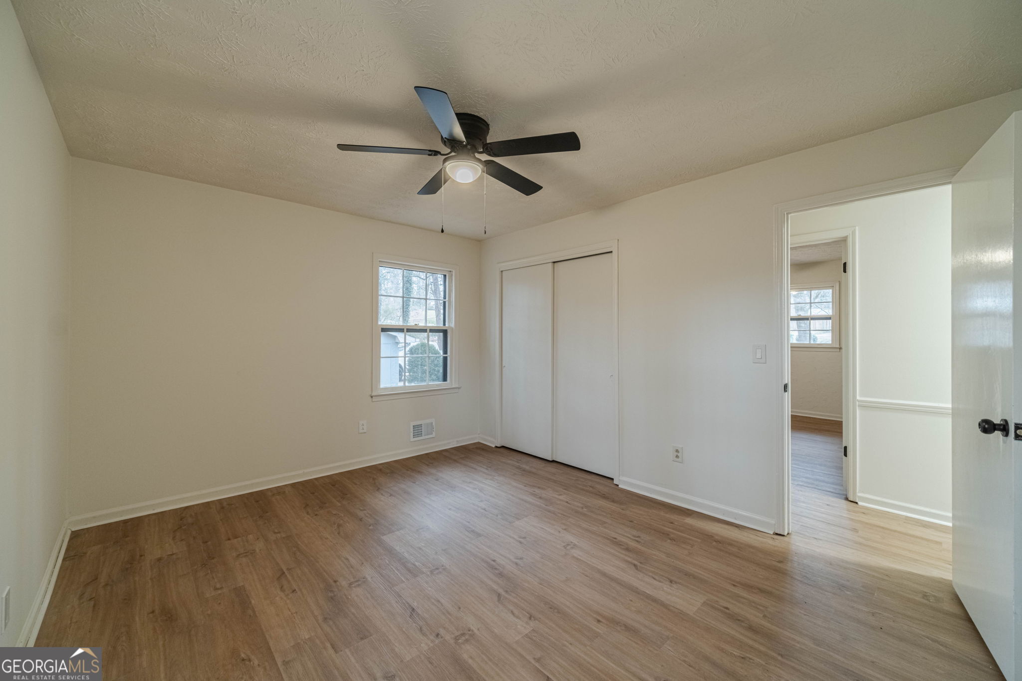 1678 Pounds Road Southwest Stone Mountain, GA 30087 - Photo 20 of 30 a view of empty room with wooden floor and fan