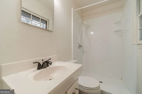 a bathroom with a sink a toilet and a mirror
