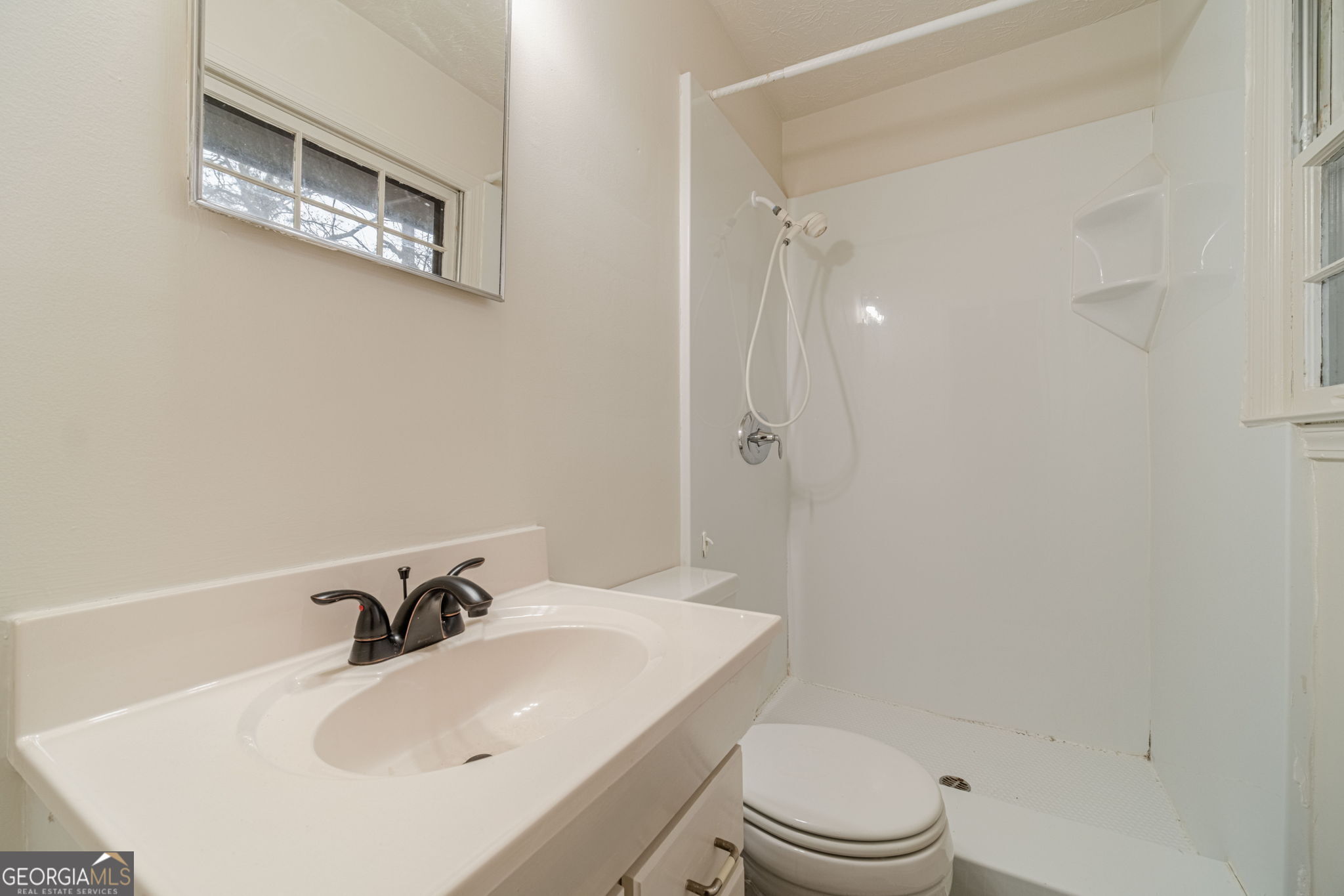 1678 Pounds Road Southwest Stone Mountain, GA 30087 - Photo 21 of 30 a bathroom with a sink a toilet and a mirror
