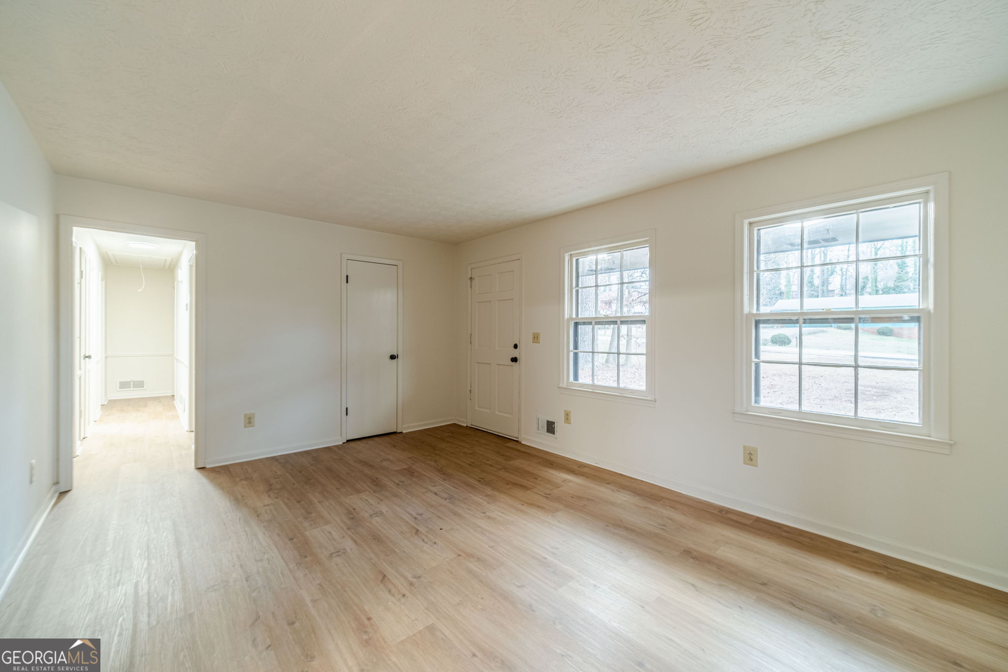 1678 Pounds Road Southwest Stone Mountain, GA 30087 - Photo 5 of 30 an empty room with wooden floor and windows