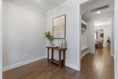 a view of a hallway with wooden floor and a potted plant