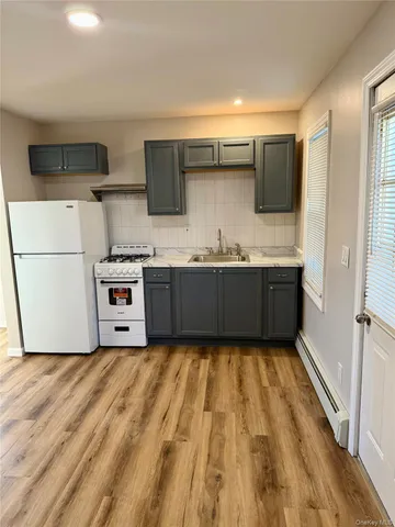 a large kitchen with stainless steel appliances granite countertop a sink and white cabinets