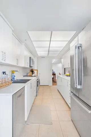 a large white kitchen with cabinets and a refrigerator