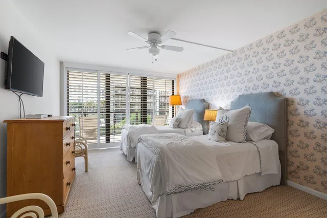 a bed room with a bed television and a large window