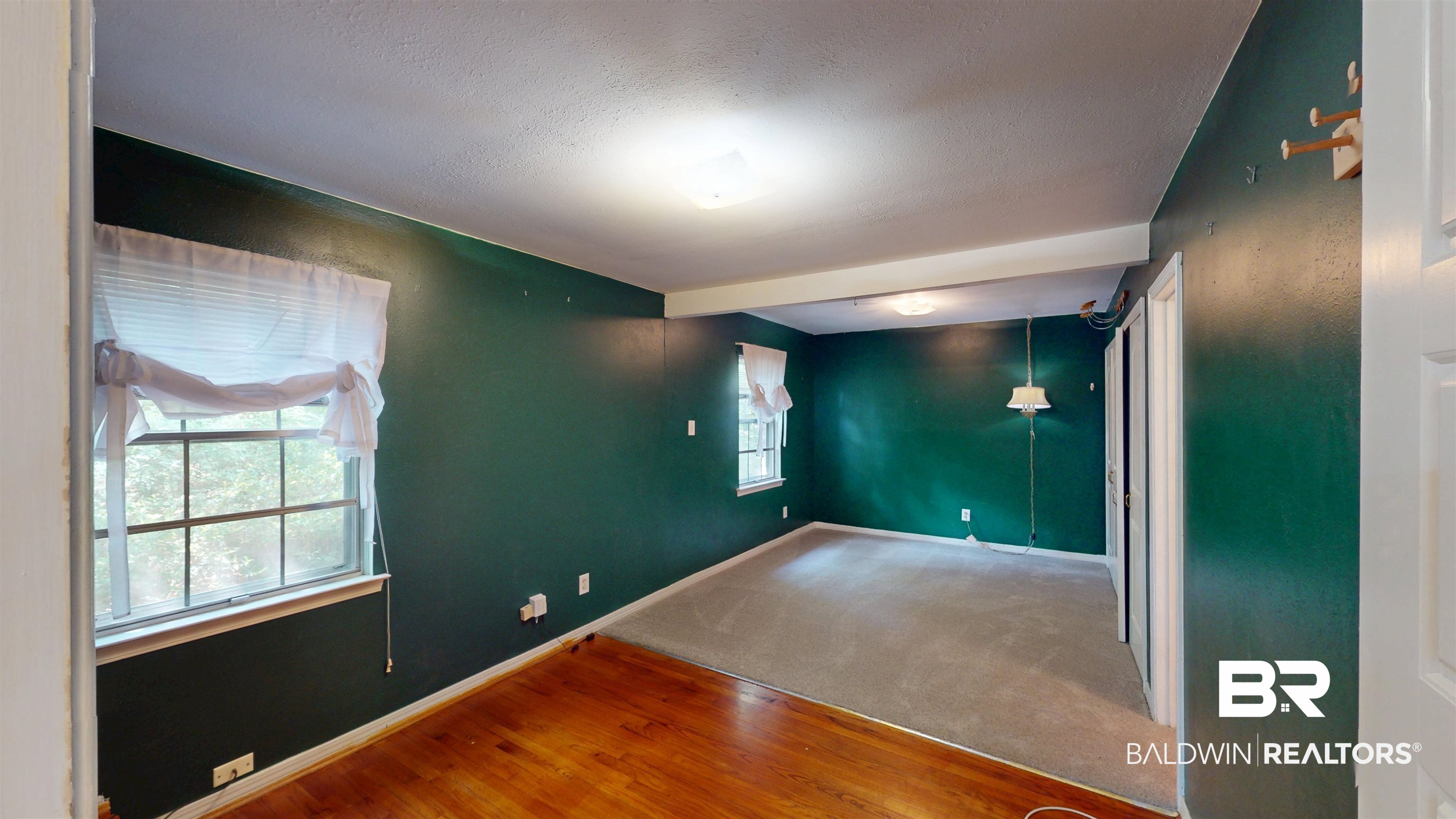 1075 Zurich Street Mobile, AL 36608 - Photo 24 of 35 Carpeted spare room featuring wood finished floors and a textured ceiling