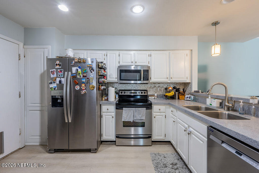 127 Sand Castle Way Neptune Beach, FL 32266 - Photo 17 of 36 a kitchen with stainless steel appliances granite countertop a refrigerator stove and sink