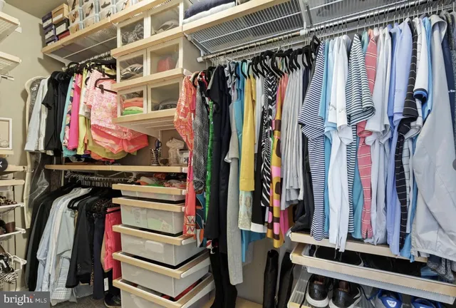 a view of walk in closet with clothes