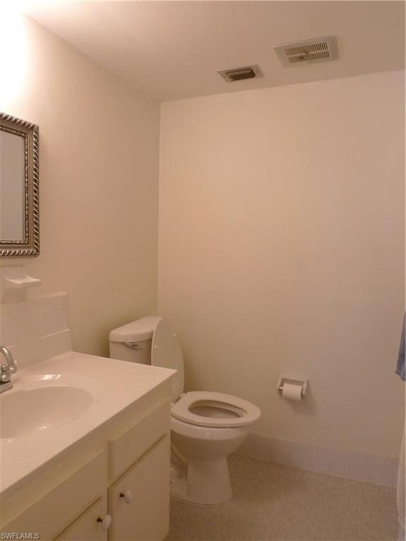 72 7th Street South, Unit 203 Naples, FL 34102 - Photo 12 of 23 a bathroom with a toilet a sink and mirror