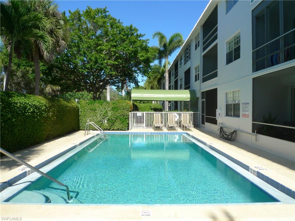 72 7th Street South, Unit 203 Naples, FL 34102 - Photo 15 of 23 a view of a swimming pool with a bench