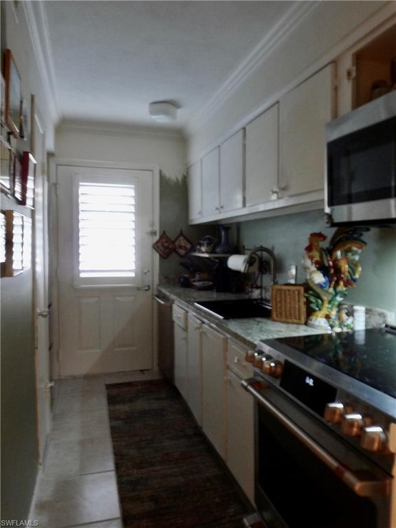 72 7th Street South, Unit 203 Naples, FL 34102 - Photo 9 of 23 a kitchen with sink a microwave and cabinets