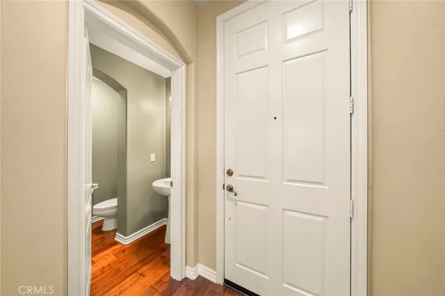 an empty room with wooden floor ceiling fan and windows
