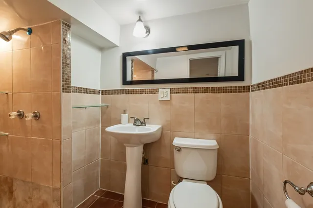 a bathroom with a toilet sink and mirror