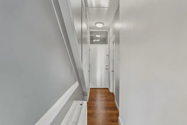 a view of a hallway with white walls and stairs