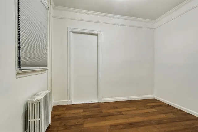 a view of a small space with wooden floor and a window
