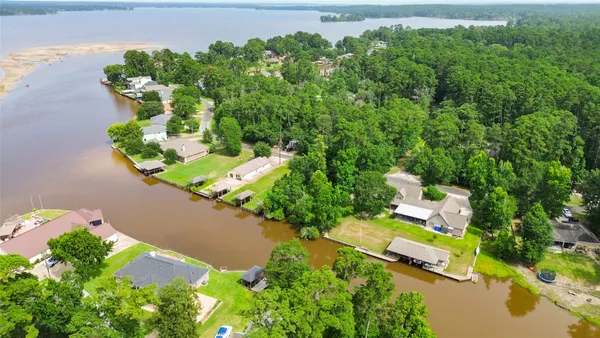 an aerial view of a house with a yard and lake view