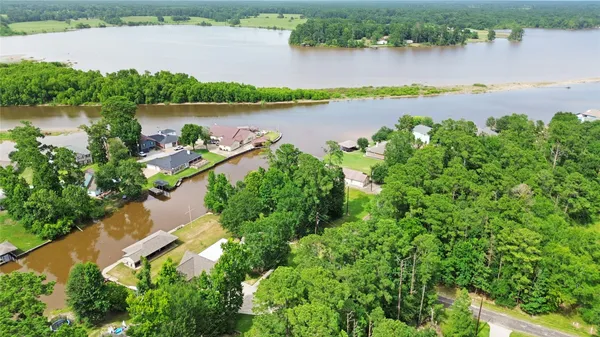 an aerial view of a residential houses with outdoor space and lake view