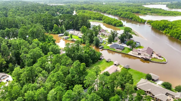 an aerial view of lake residential house with outdoor space and trees all around