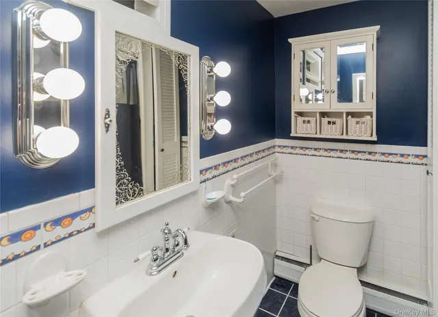 a bathroom with a toilet a sink and mirror