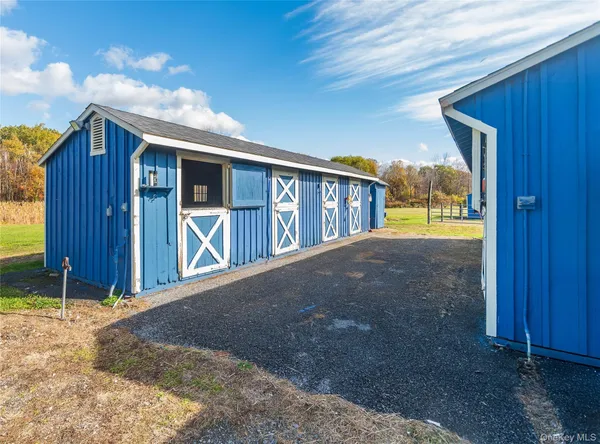 a view of backyard with large trees and wooden fence
