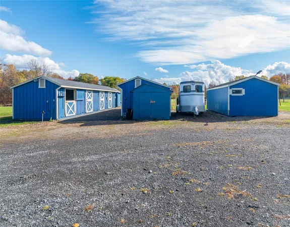 a view of a house with a yard and large trees