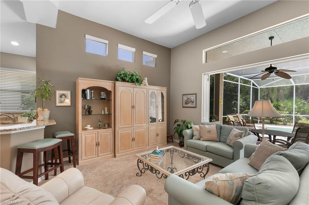 1717 Winding Oaks Way Naples, FL 34109 - Photo 11 of 35 Living room featuring light colored carpet, a high ceiling, and ceiling fan