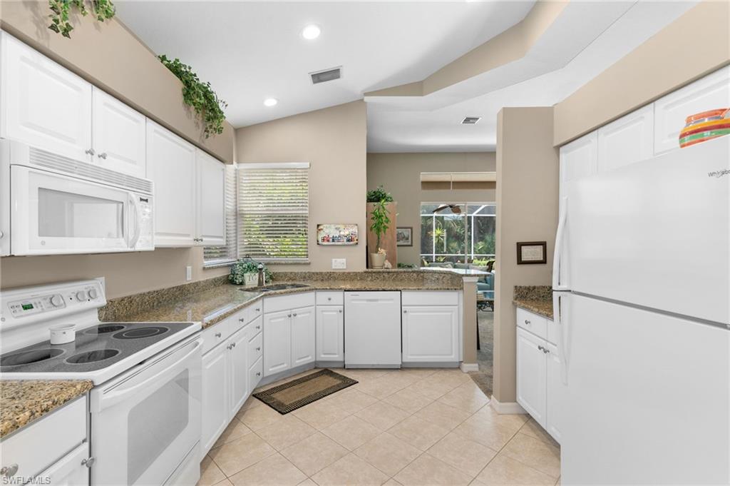 1717 Winding Oaks Way Naples, FL 34109 - Photo 14 of 35 Kitchen featuring sink, light tile flooring, white appliances, and white cabinetry