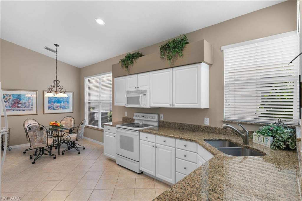 1717 Winding Oaks Way Naples, FL 34109 - Photo 15 of 35 Kitchen with decorative light fixtures, sink, white cabinets, and white appliances