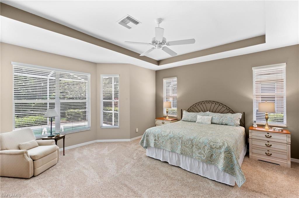 1717 Winding Oaks Way Naples, FL 34109 - Photo 17 of 35 Bedroom featuring ceiling fan, a tray ceiling, and light colored carpet